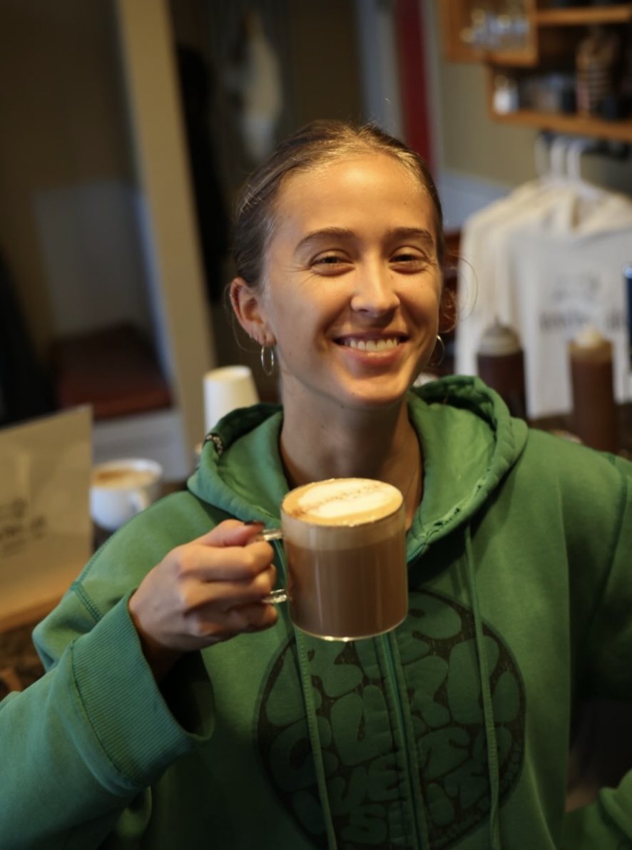 A barista holding a fresh latte